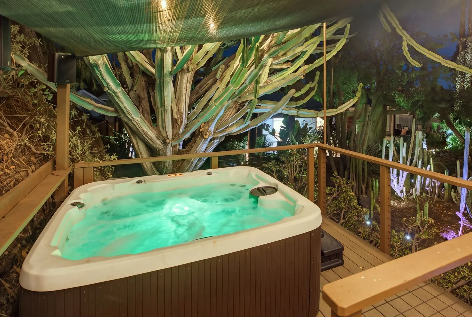 Six-person hot tub glowing on the raised deck at night